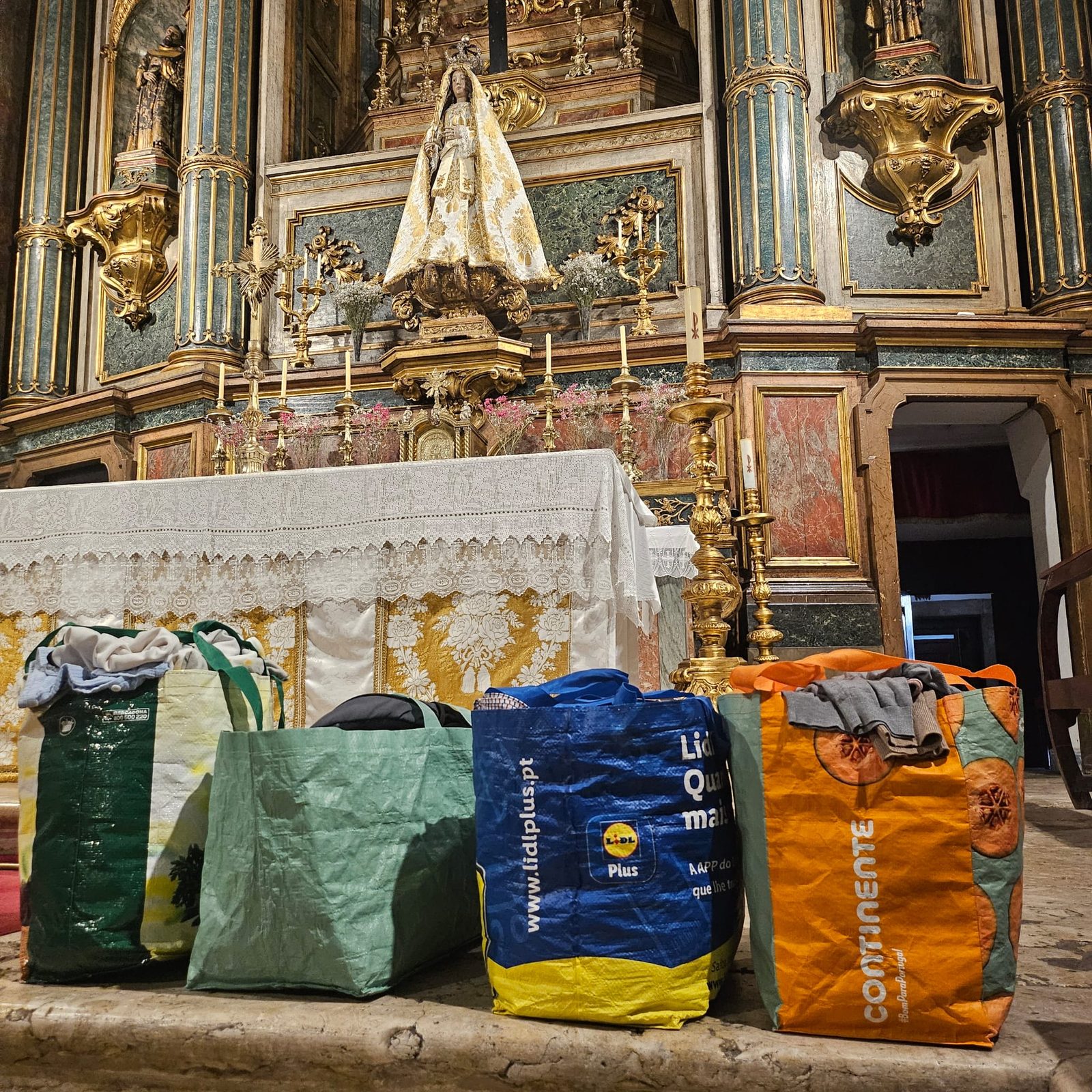 Sacos de doações junto ao altar — apoio a famílias em necessidade