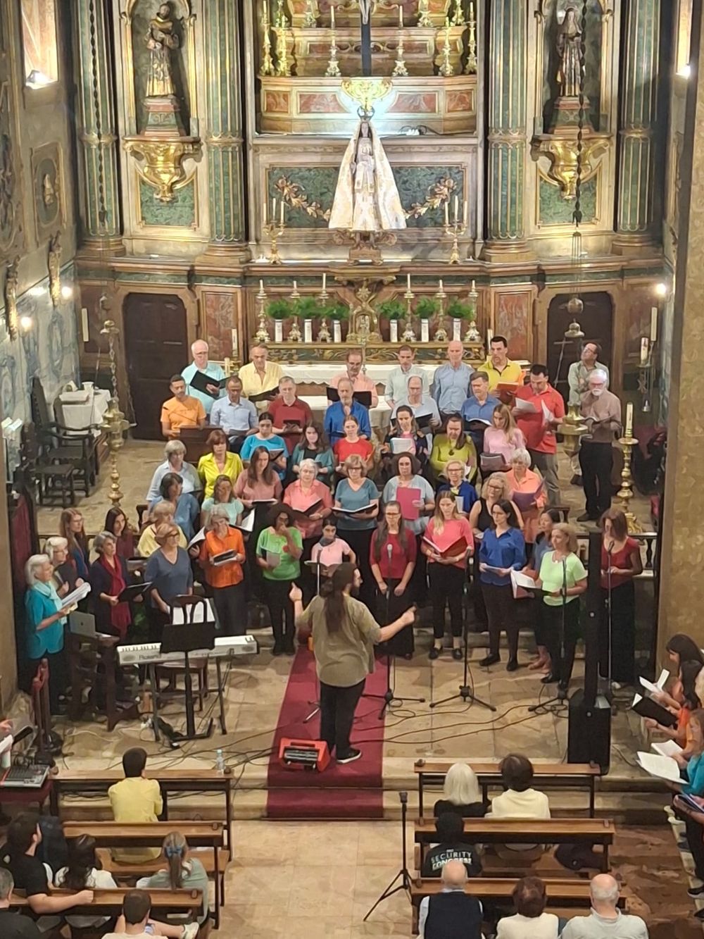 O Lisbon Community Choir a cantar diante do altar-mor com a imagem de Nossa Senhora da Quietação, 17 de Outubro de 2026