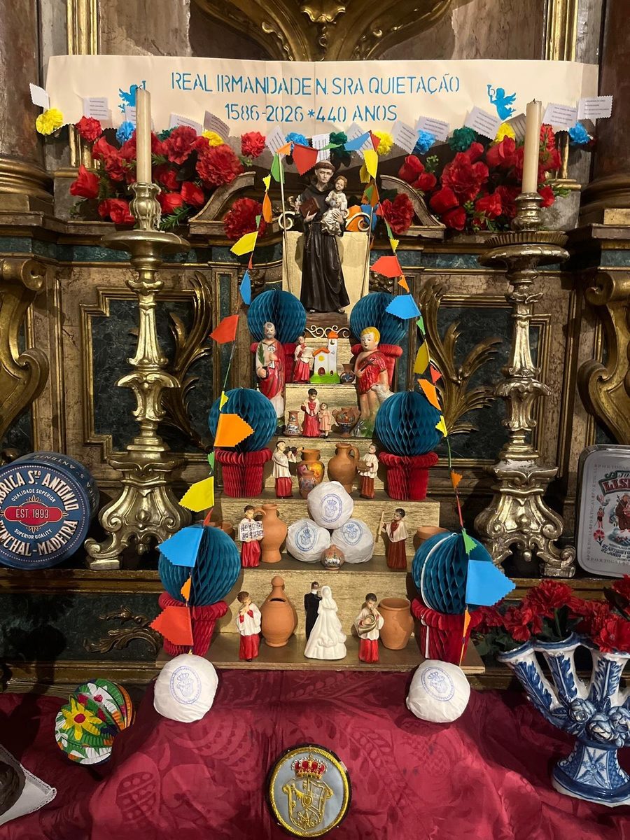 Trono de Santo António 2026 na Igreja das Flamengas — papel picado, cravos de papel, figuras tradicionais e cartaz «Real Irmandade N. Sra. Quietação · 1586-2026 · 440 anos»